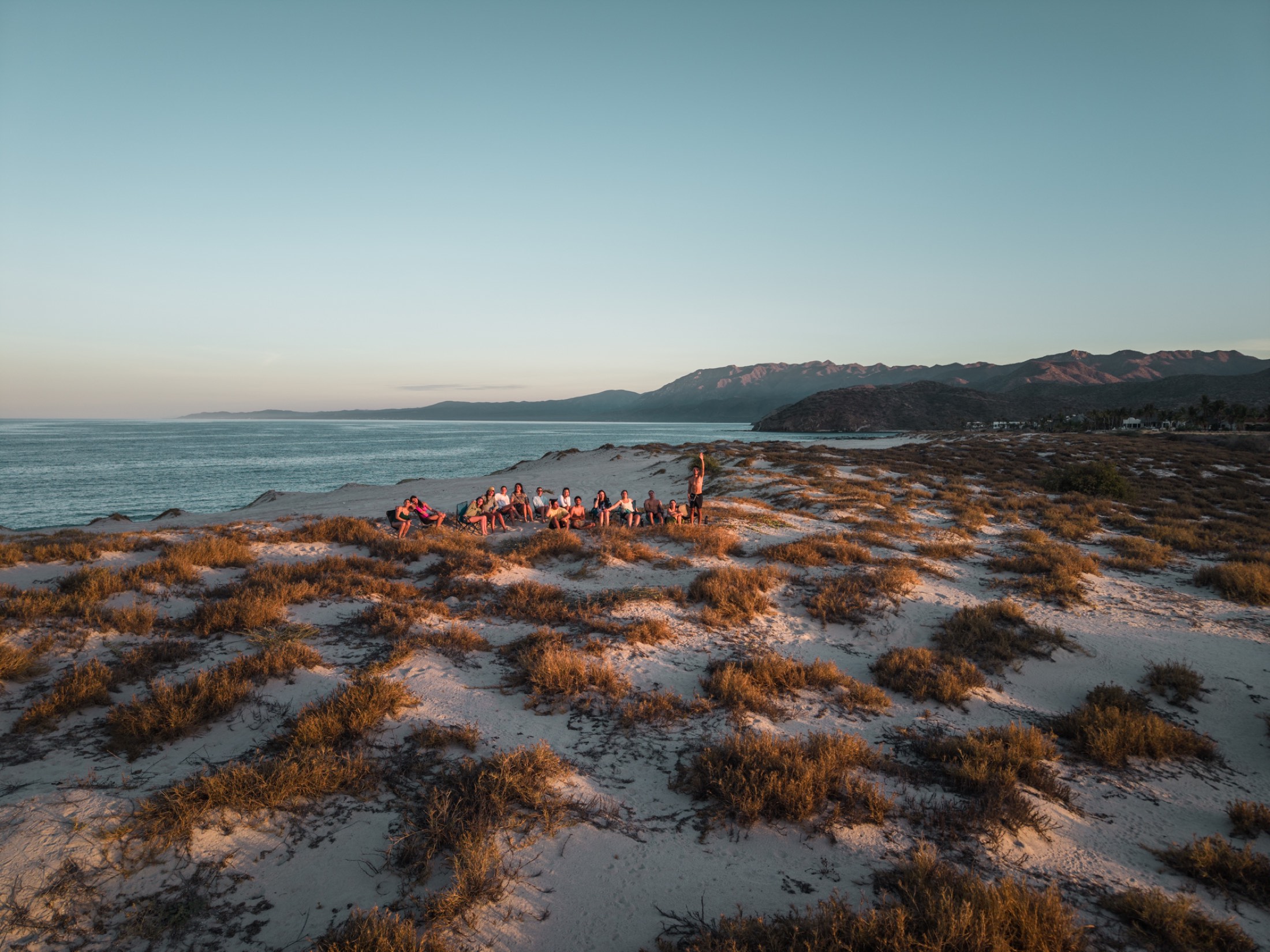 Personas al atardecer en la costa